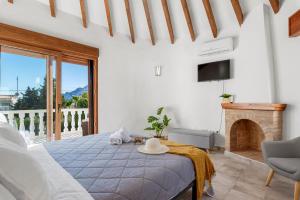 a white bedroom with a bed and a fireplace at Villa K9 Ortenbach in Ifach