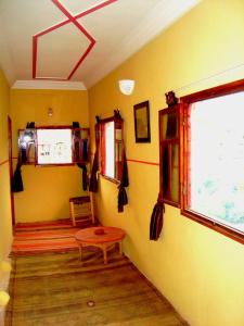 a room with yellow walls and a table and a window at Auberge Tigmmi N'Tamazirte in Ijjoukak