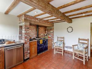 a kitchen with a brick wall and two chairs at 3 Bed in Bridgnorth 86516 