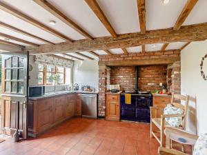 a kitchen with wooden cabinets and a brick wall at 3 Bed in Bridgnorth 86516 