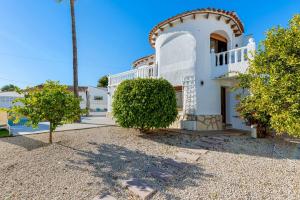 a white house with a palm tree in front of it at Villa K9 Ortenbach in Ifach