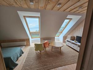 a bedroom with a bed and a table and two windows at Puulaiu kõrts majutus in Nasva