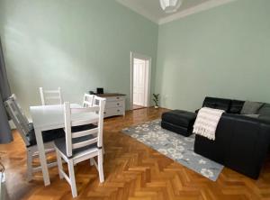 salon z kanapą, stołem i krzesłami w obiekcie Heart of Budapest w Budapeszcie