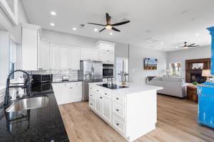 a kitchen with white cabinets and a ceiling fan at 061 Bay Breezes on Port Royal in Dauphin Island