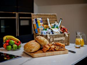 a table with a plate of bread and a basket of fruit at 4 Bed in Westward Ho 86640 in Bideford