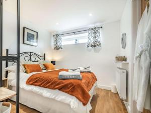 una camera con un letto e una coperta arancione di 2 bed property in Bradford-on-Avon 87056 a Southwick