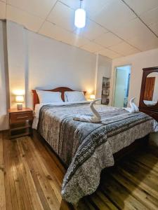 Un dormitorio con una cama con dos pájaros. en Hermosa casita en centro de Cuenca, en Cuenca