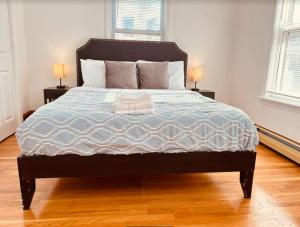 a bedroom with a large bed with two lamps on tables at 17 Cozy&Spacious 3 bedroom home in Malden in Malden