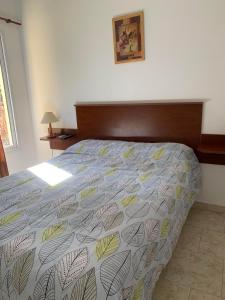 ein Schlafzimmer mit einem Bett mit einer Bettdecke mit Blättern darauf in der Unterkunft Complejo Rincon del Uruguai in Colón