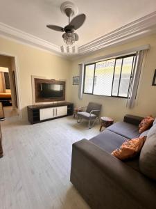 Il comprend un salon doté d'un canapé et d'une télévision à écran plat. dans l'établissement Apartamento Temporada Guarujá, à Guarujá