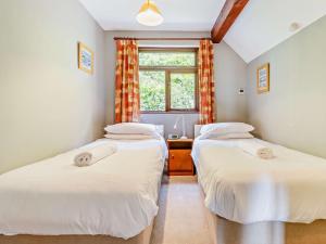 2 Einzelbetten in einem Zimmer mit Fenster in der Unterkunft 3 Bed in Aberdovey DY032 in Aberdyfi