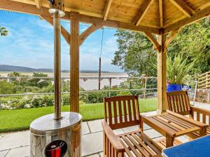 2 Stühle und ein Tisch auf einer Veranda mit Aussicht in der Unterkunft 3 Bed in Aberdovey DY032 in Aberdyfi