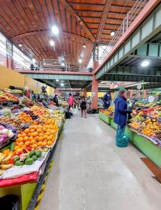 people standing in a market with fruits and vegetables at Hermosa casita en centro de Cuenca in Cuenca