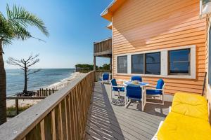 una casa con terrazza arredata con tavolo e sedie di 069 Sandcastle 5F a Dauphin Island
