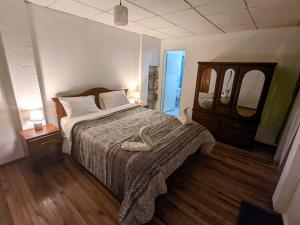 a bedroom with a large bed and two mirrors at Hermosa casita en centro de Cuenca in Cuenca