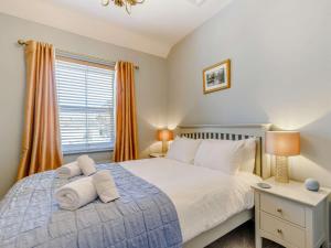 1 dormitorio con 1 cama y una ventana con cortinas de color naranja en 2 Bed in Bakewell 88661, en Bakewell