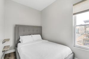 a white bed in a room with a window at Spacious Hideaway minutes from Downtown with Parking in Chicago