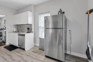 um frigorífico de aço inoxidável numa cozinha com armários brancos em Spacious Hideaway minutes from Downtown with Parking em Chicago