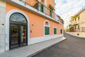 Un edificio naranja con una puerta que da a una calle. en Nisida View Apartment by Wonderful Italy, en Pozzuoli