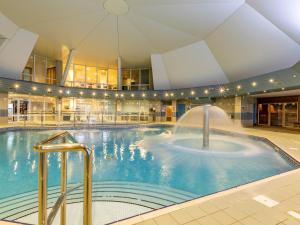 a large swimming pool with a fountain in a building at 3 Bed in St. Mellion 87719 in St Mellion