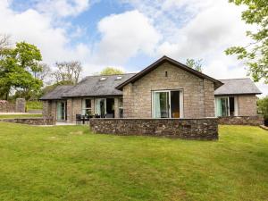 a brick house with a stone wall in a yard at 3 Bed in St. Mellion 87719 in St Mellion