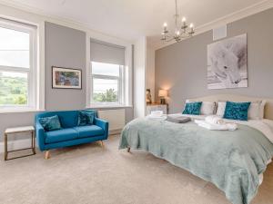 a bedroom with a bed and a blue chair at 4 Bed in Matlock 88011 in Matlock