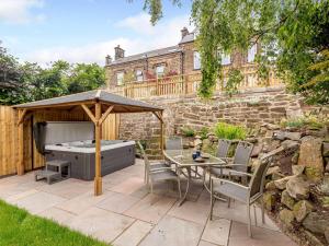 a patio with a table and an umbrella at 4 Bed in Matlock 88011 in Matlock