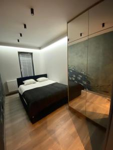 sypialnia z łóżkiem i szklaną ścianą w obiekcie Beautiful Apartment Tarasy Wiślane Free GARAGE w Krakowie