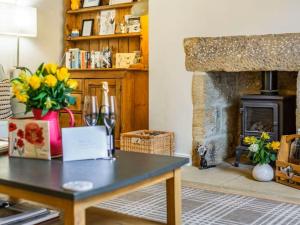 Una sala de estar con una mesa y una chimenea. en Falstaff House, listed building, a delightful late-Georgian holiday cottage in a great location in central Alnwick, en Alnwick