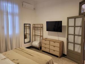 Schlafzimmer mit einem Bett und einer Kommode mit einem TV in der Unterkunft Casa Supremo in Concepción del Uruguay