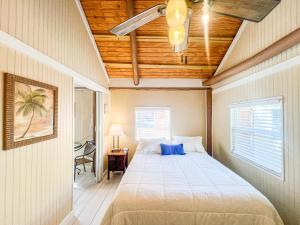 a bedroom with a bed with a blue pillow on it at Sunset Cove Beach Resort in Key Largo