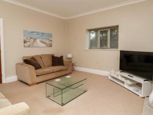 a living room with a couch and a television at 6D Clifton Drive in Lytham St Annes