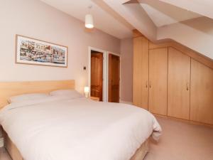 a bedroom with a large white bed and wooden cabinets at 6D Clifton Drive in Lytham St Annes