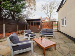 a patio with two chairs and a wooden table at 6D Clifton Drive in Lytham St Annes