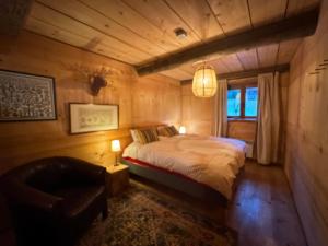 アボンダンスにあるWarm and Stylish Boutique Lodge L'Etoile de Savoieのベッドルーム1室(ベッド1台、椅子1脚付)