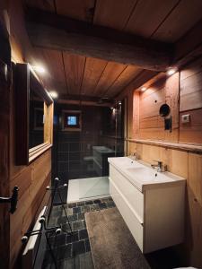 a bathroom with a white sink and a shower at Warm and Stylish Boutique Lodge L'Etoile de Savoie in Abondance