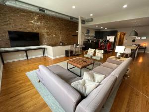 a living room with a couch and a brick wall at Trendy Wicker Park Loft with Parking in Chicago