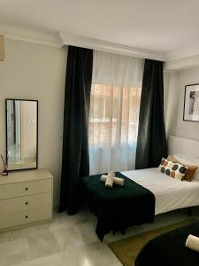 una camera con letto e finestra con specchio di Magna Marbella Golf Resort Apartment a Marbella