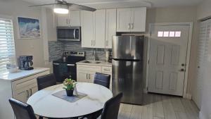 cocina con mesa y nevera de acero inoxidable en Beach Front One Bedroom Condo Paradise. Ground Floor., en Longboat Key