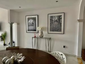 un soggiorno con tavolo e 2 immagini sul muro di Magna Marbella Golf Resort Apartment a Marbella