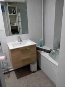 a bathroom with a sink and a tub and a mirror at Studio des Thermes 2* in Vittel