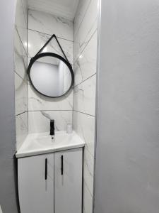 uma casa de banho branca com um espelho e um lavatório em Vusi's Guesthouse em Durban