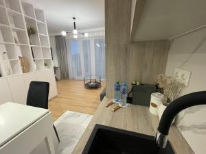 una sala de estar con 2 botellas de agua en una mesa en Rainbow Apartments Premium CENTRUM, en Kielce