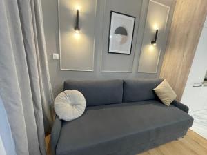 sala de estar con sofá azul y almohada en Rainbow Apartments Premium CENTRUM, en Kielce