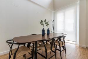 a dining room table with chairs and vases on it at Modern and wide- 3Bd 2,5 Bth- Plaza Castilla in Madrid