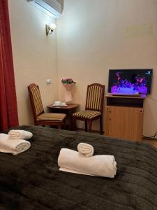 a hotel room with a bed and a tv at Лаціо in Berehove