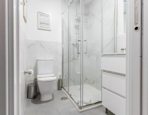 uma casa de banho com um WC e uma cabina de duche em vidro. em Bright and cozy- 1D 1B- Plaza Castilla em Madri