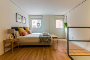 um quarto com uma cama e duas janelas em Bright and cozy- 1D 1B- Plaza Castilla em Madri