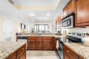 a large kitchen with wooden cabinets and granite counter tops at 314 Holiday Isle 314 in Dauphin Island