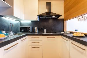 a kitchen with white cabinets and a black wall at Gressoney Saint-Jean Halldis Apartments in Gressoney-Saint-Jean